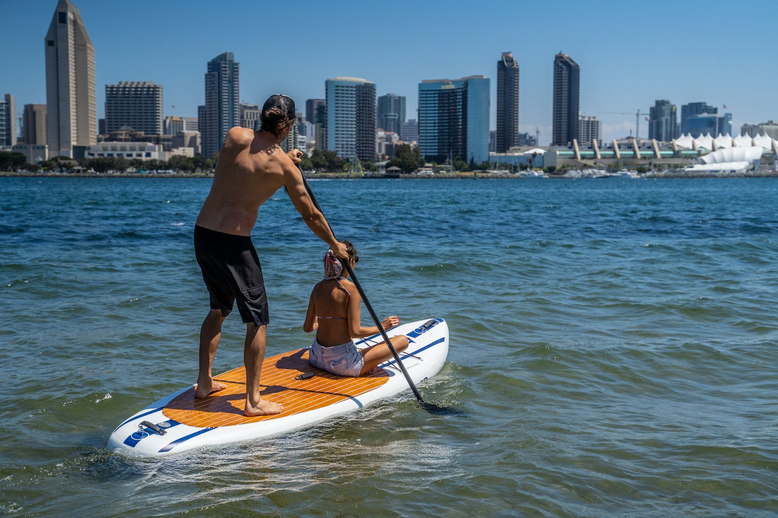 Man on a paddleboard with a young boy — SUP with kids family paddling guide